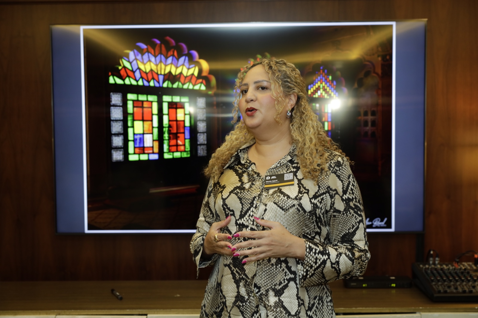 Speaker presenting in front of a stained glass image on screen